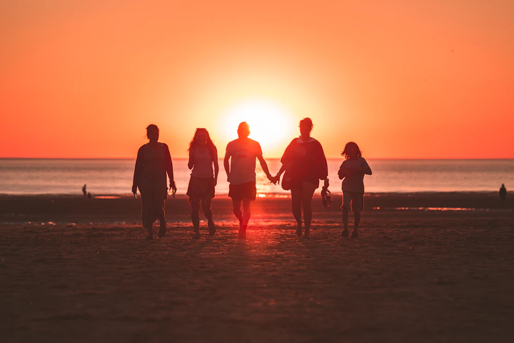 Family walking together at golden hour, hands joined