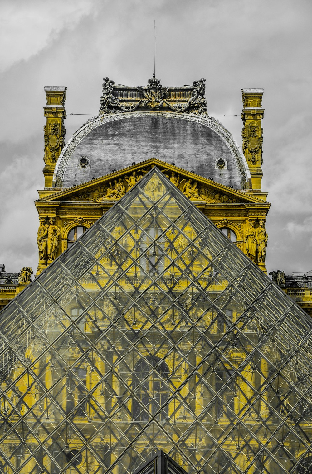 photo of glass triangle-shape building under nimbus cloud