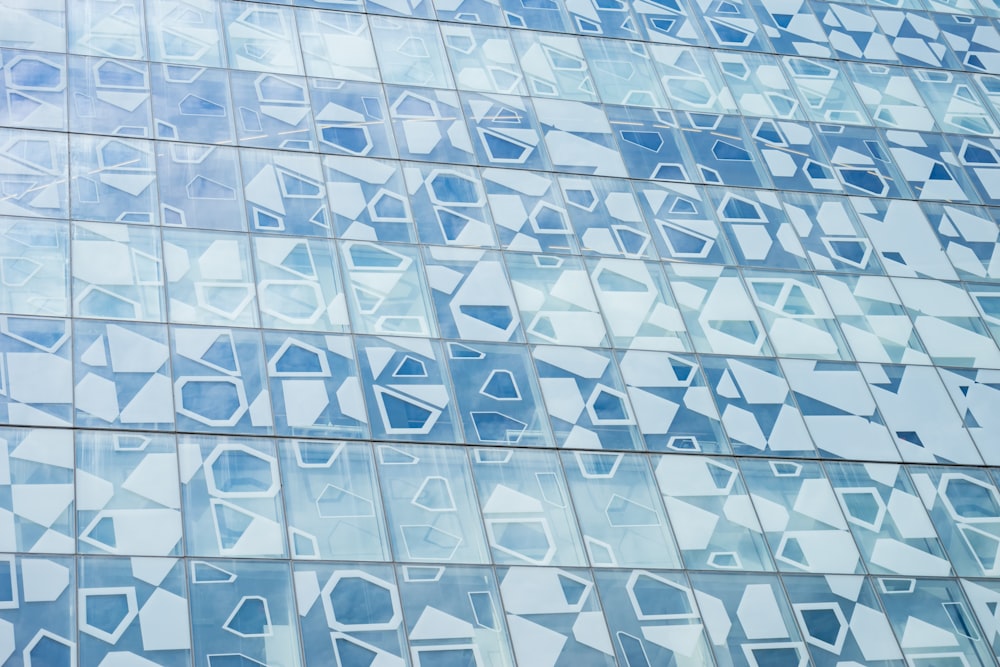 Eine blaue Fassade mit geometrischen Formen, die auf die Fenster gemalt sind