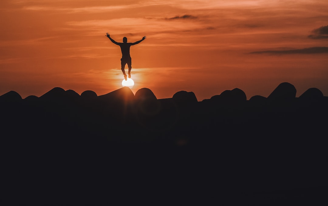 silhouette of person jumping in mid air