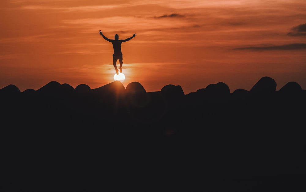 silhouette of person jumping in mid air