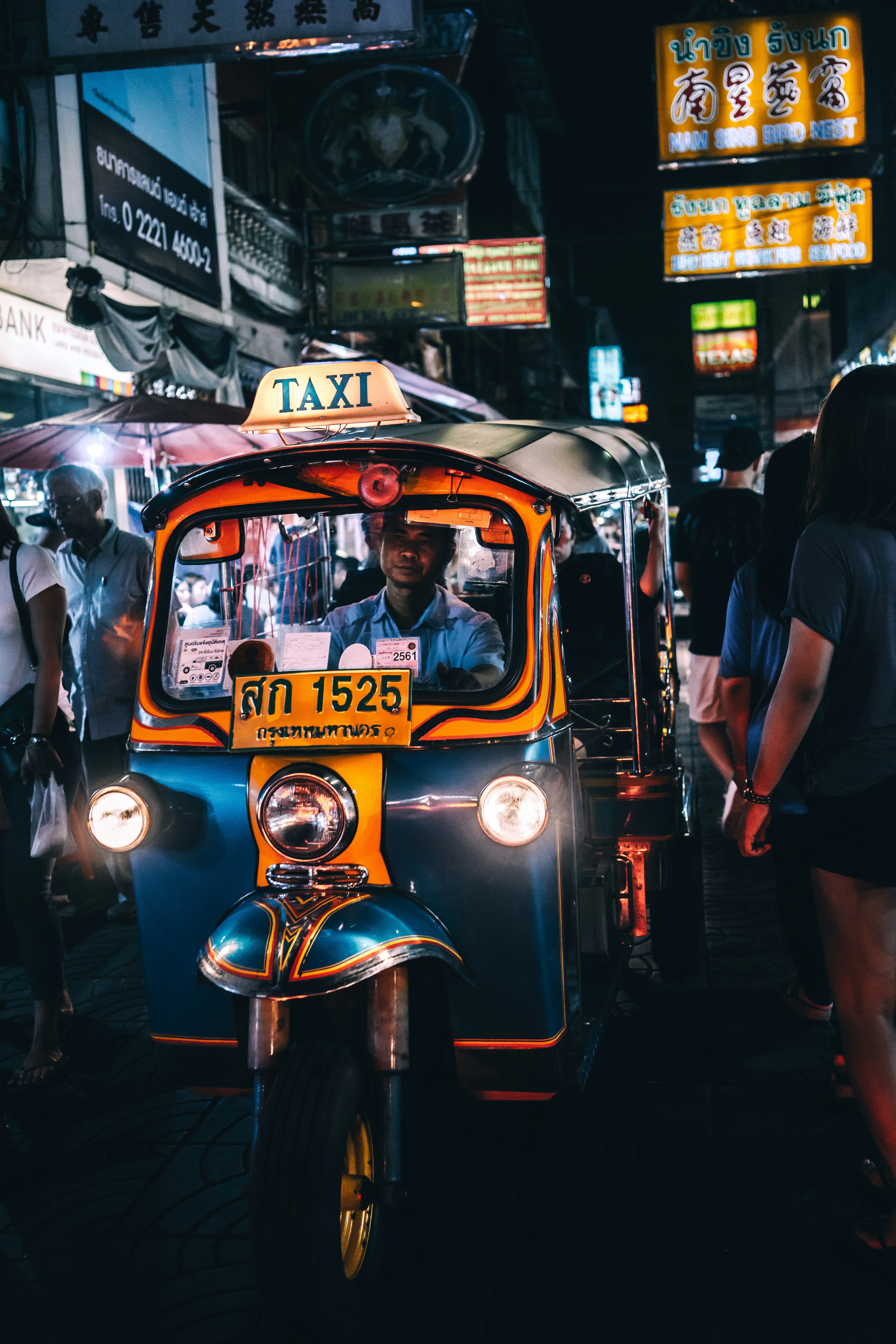 A Tuk-Tuk driver makes his way through a crowd in the busy Chinatown area of Bangkok, Thailand.