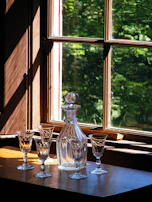 A set of sleek, eco-friendly glassware catching the afternoon sun on a minimalist dining shelf.