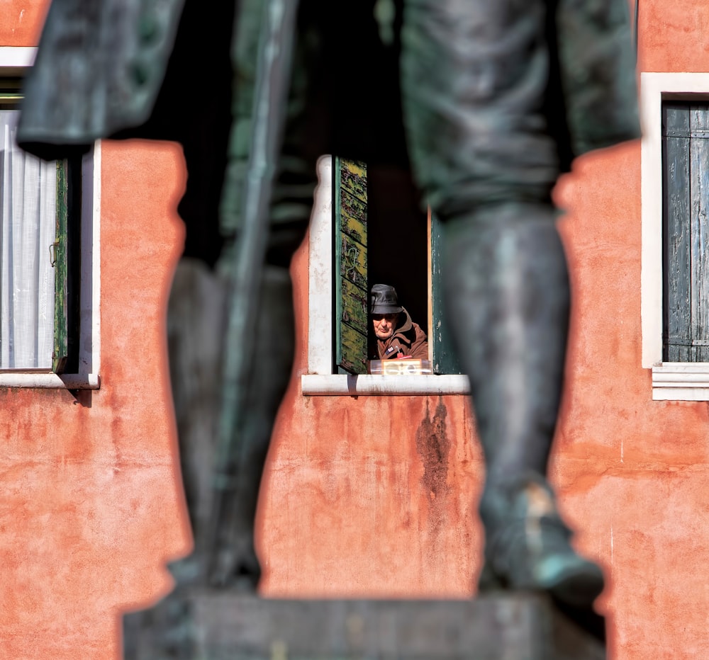 a statue of a man looking out of a window