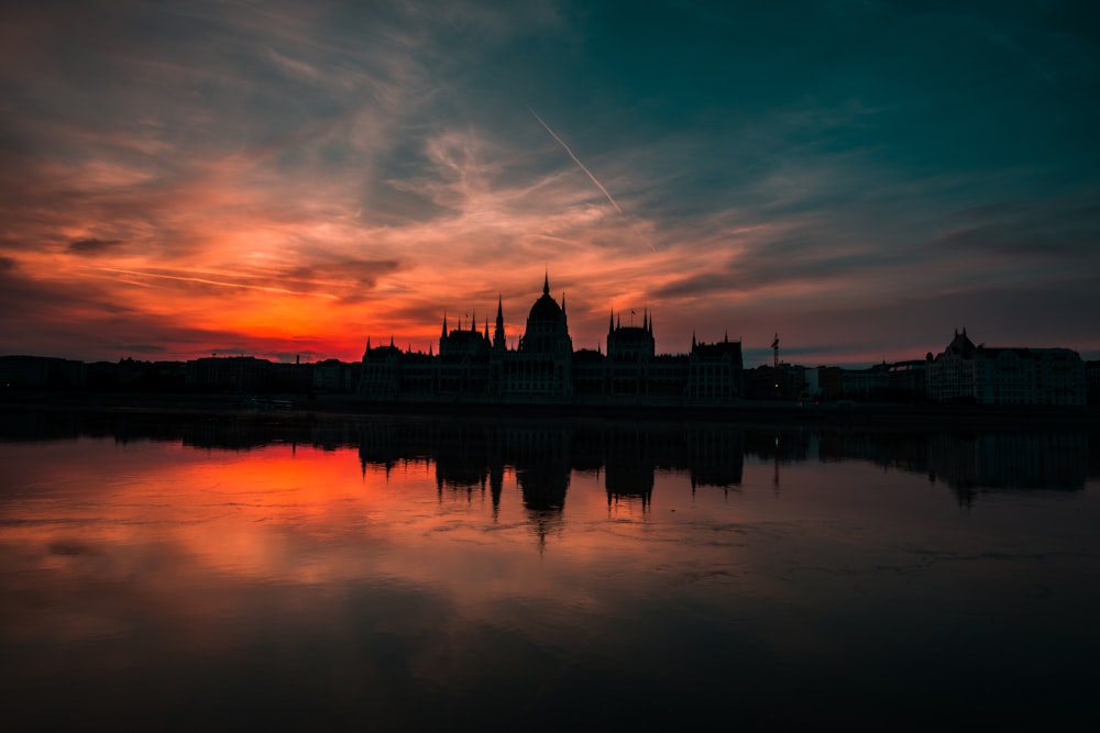 silhouette of building under gray sky during golden hour