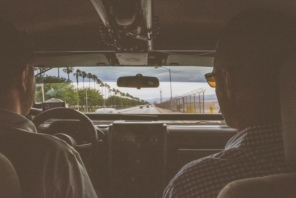 shallow focus photography of two man riding a car