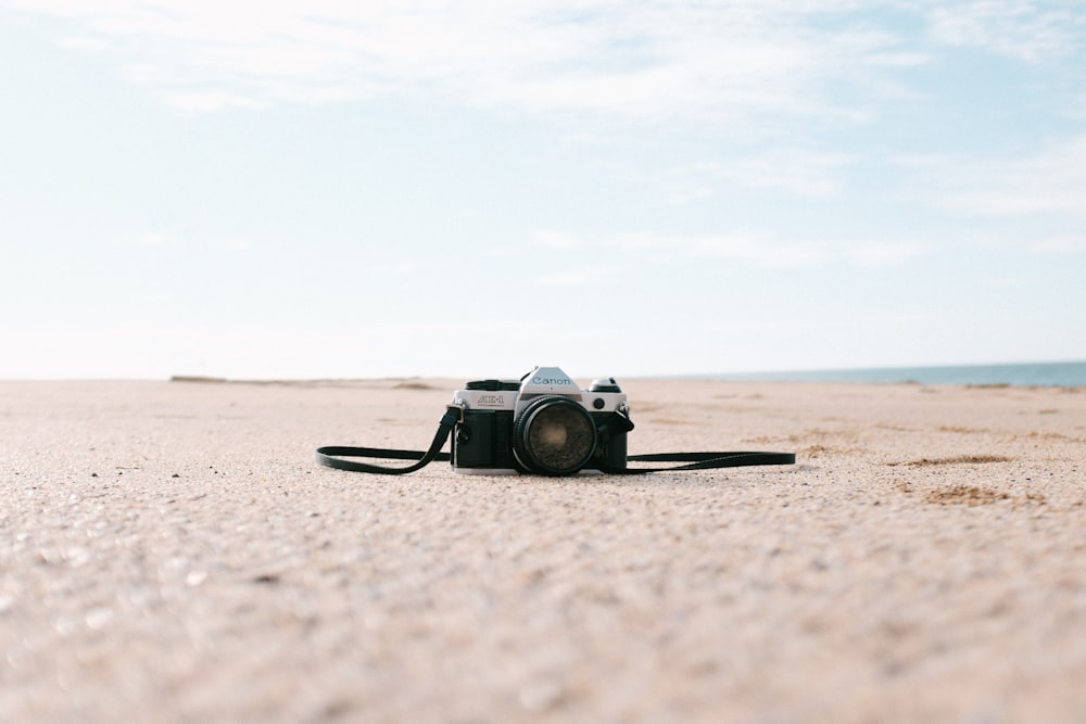 black and silver SLR camera on seashore