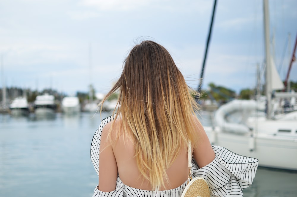 woman standing in front of white yacht