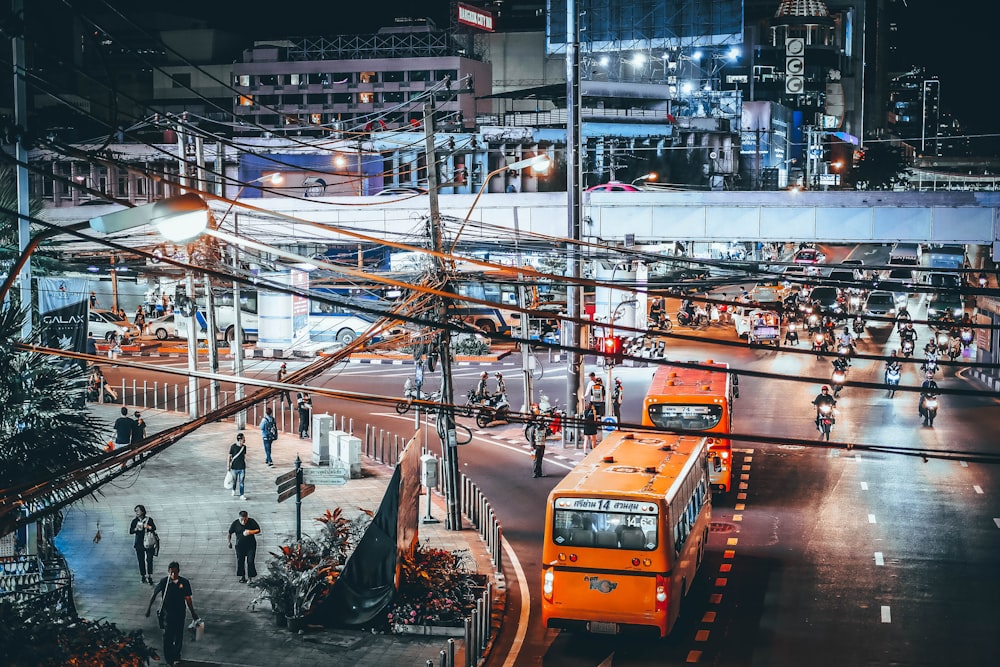 two yellow bus beside street during night time