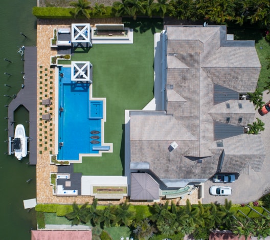 bird's eye view of house with pool near body of water