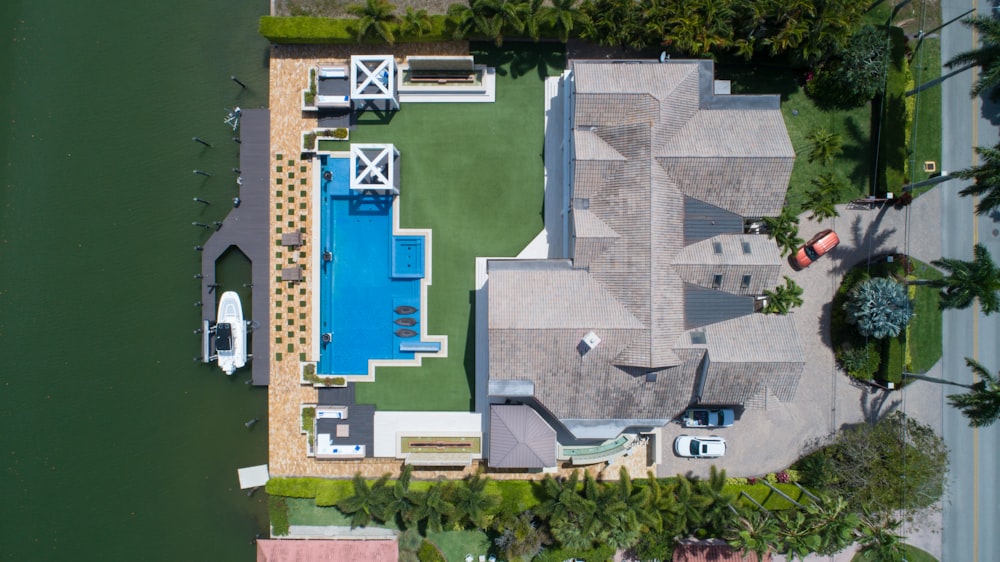 Vista de pájaro de la casa con piscina cerca del cuerpo de agua