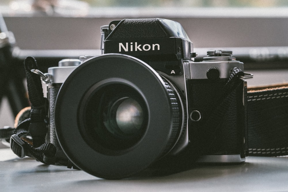 cámara milc Nikon negra sobre panel blanco