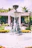 A beautifully crafted decorative concrete fountain in a lush garden setting.