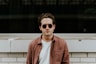 man standing in front of white concrete wall