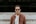 man standing in front of white concrete wall