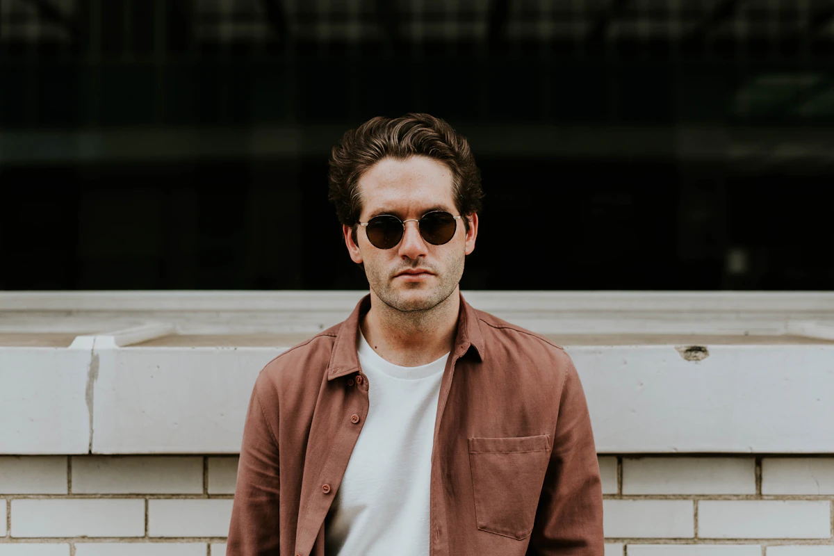 Man wearing modern dark menswear in editorial light