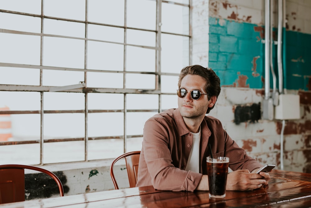 man sitting on chair holding phone