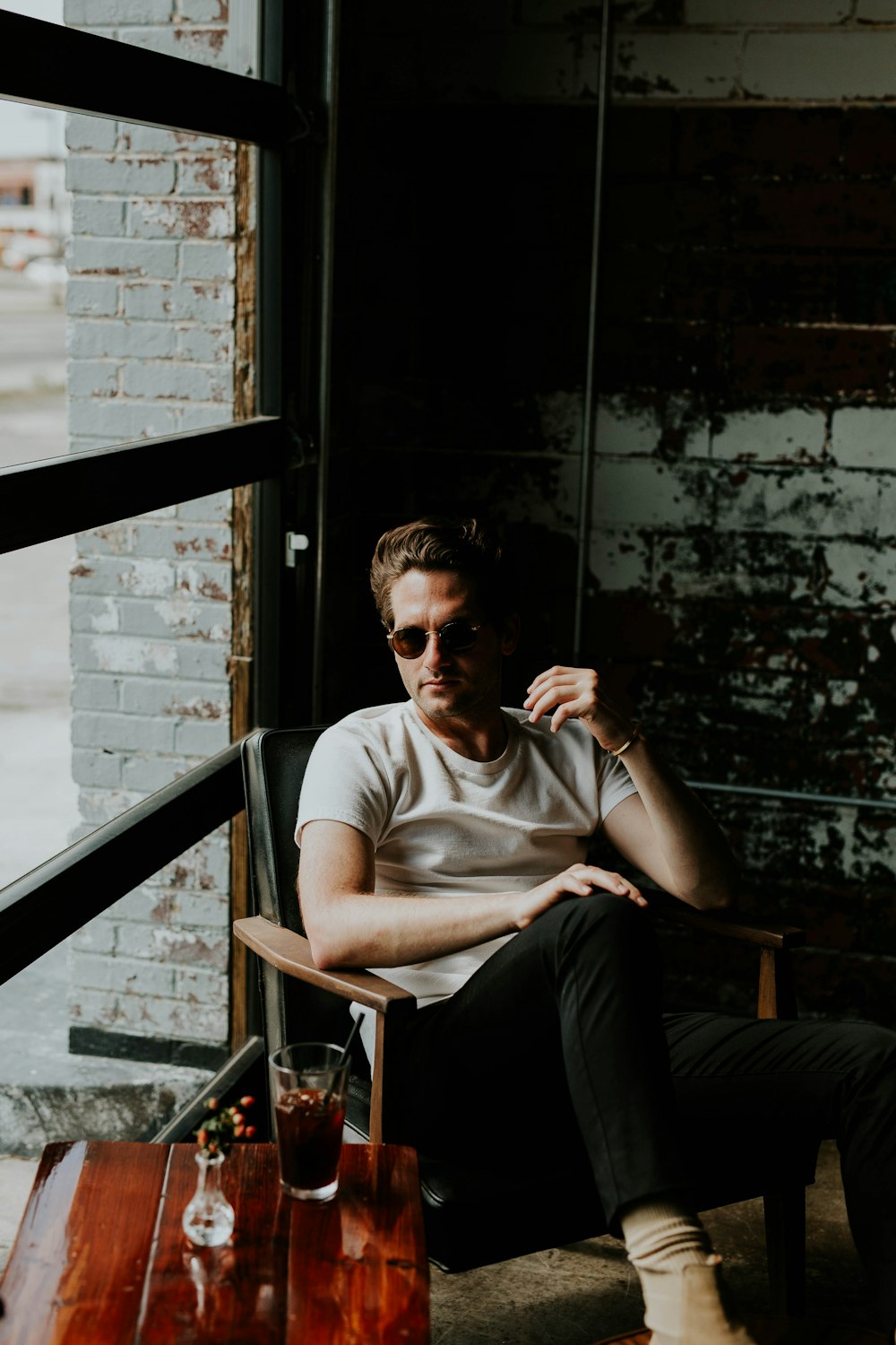 man sitting on a armchair beside window