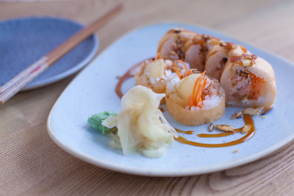 A plate of sushi with caramel colored sauce.