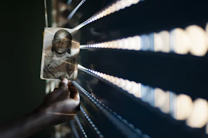 A close-up of a hand gently holding a photo of a family, symbolizing memories after a traffic accident