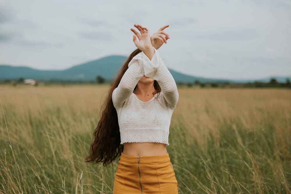 woman wearing gray crop top sweater on grass field