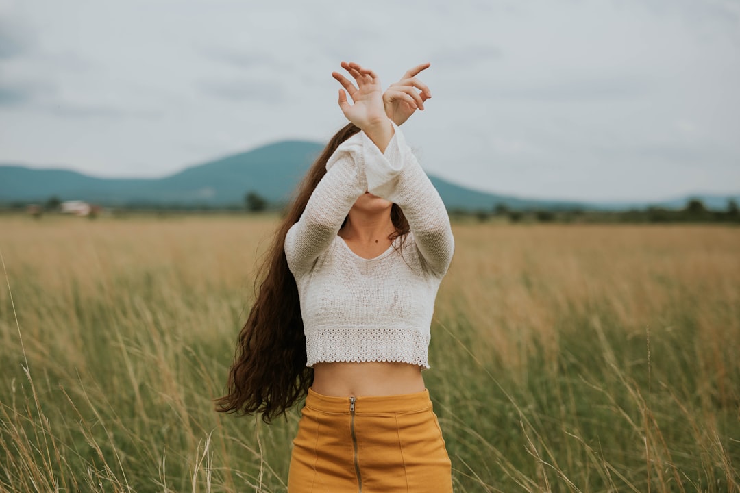 woman wearing gray crop top sweater on grass field