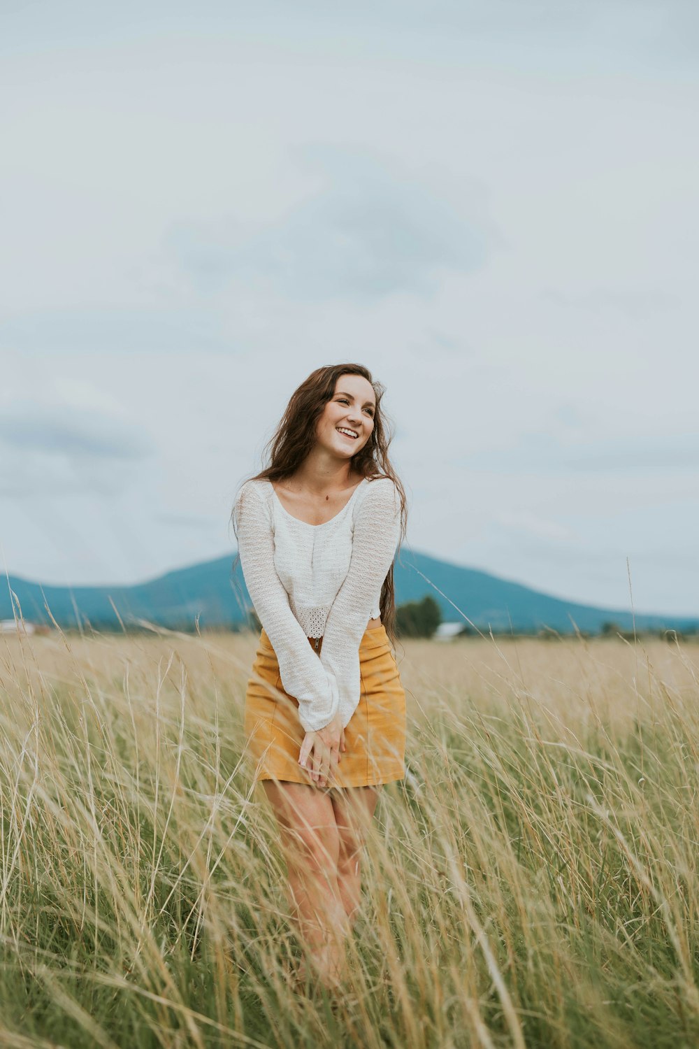 woman wearing brown long-sleeved shirt on green grass field