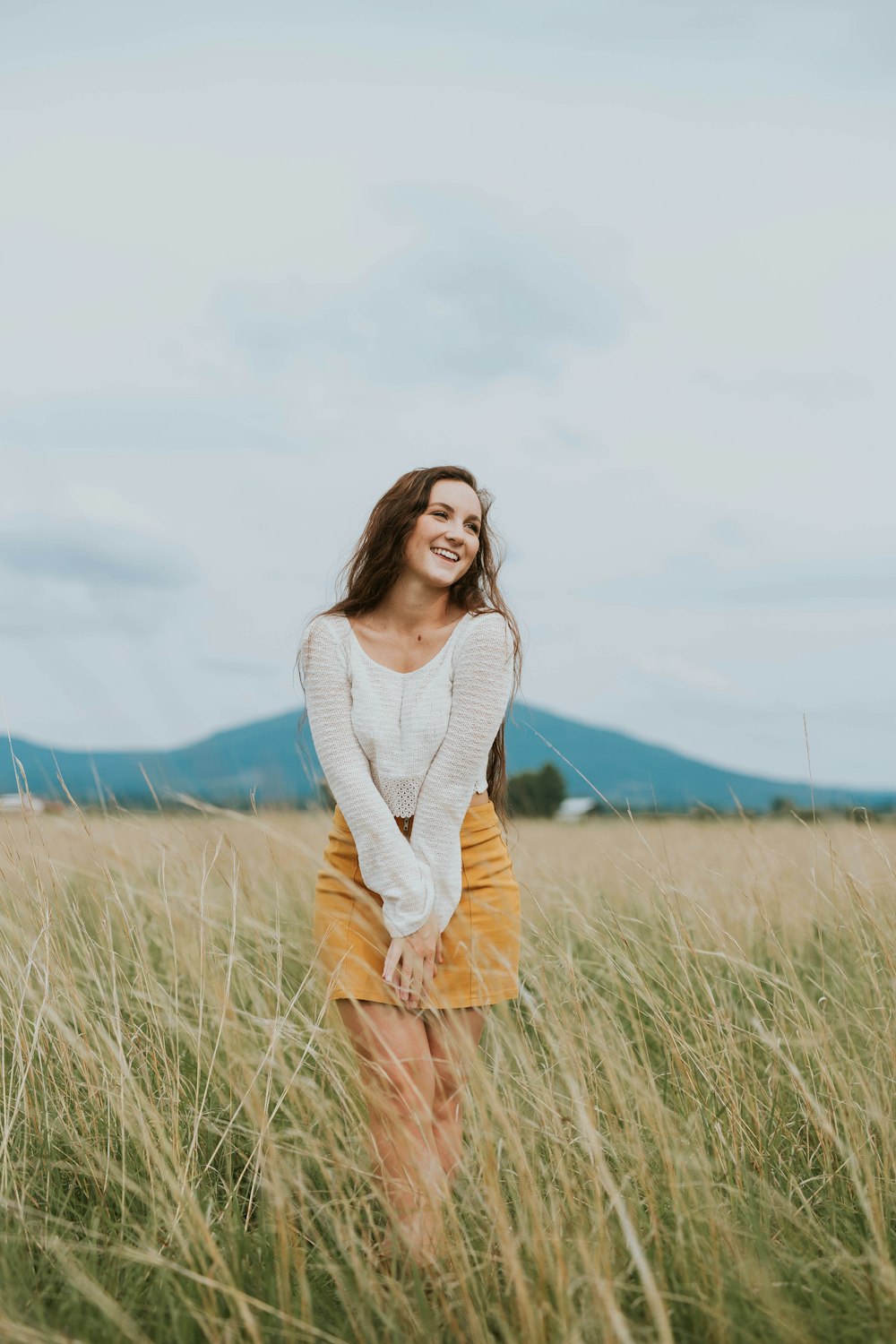 Donna che indossa una camicia a maniche lunghe marrone sul campo di erba verde