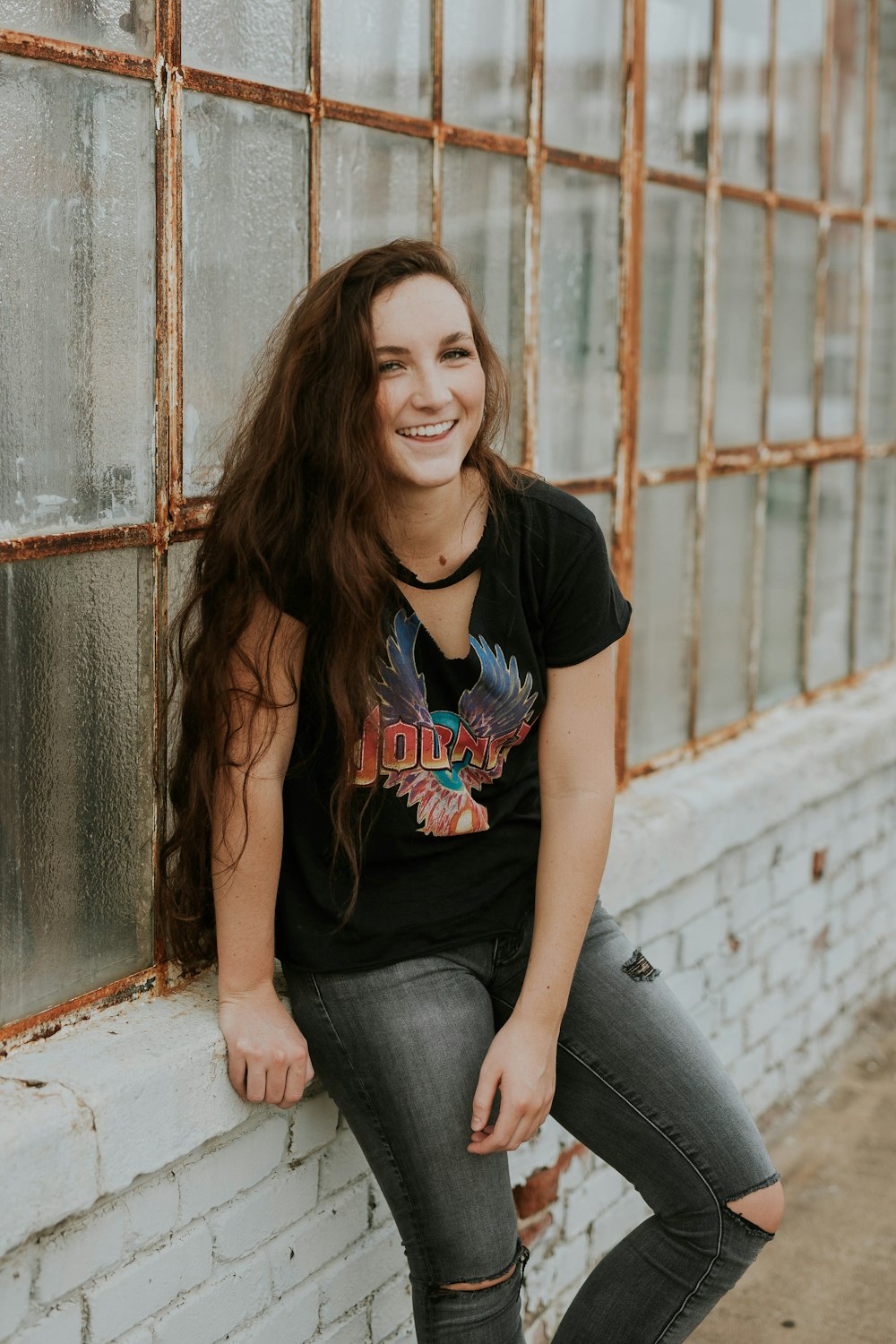 woman sitting on windowsill laughing