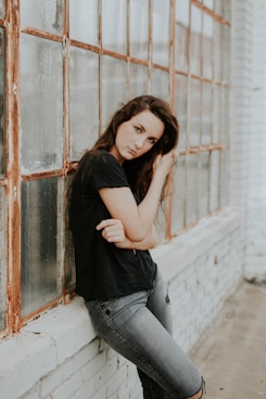 woman and black crew-neck T-shirt lying beside glass window onlyfans