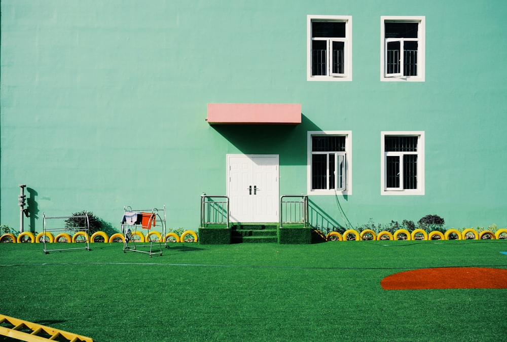Grün gestrichenes Gebäude neben Rasen