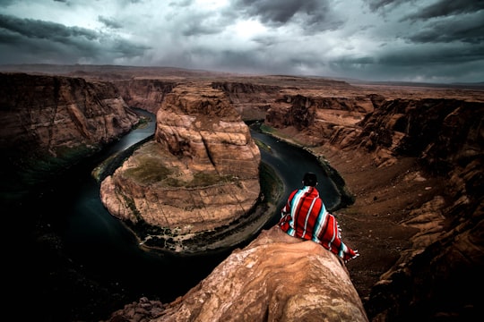 person sitting on rock formation during daytime in Page United States