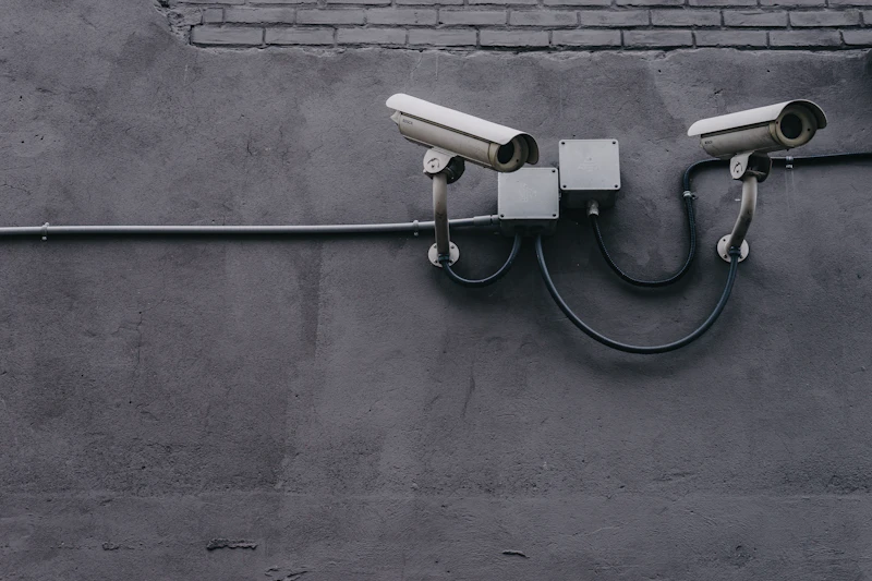 Two security cameras mounted on a gray wall