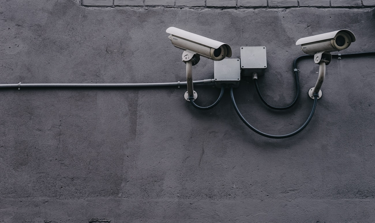 two bullet surveillance cameras attached on wall