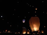 A vibrant lantern festival at dusk, with glowing lanterns floating gently above the monastery grounds.