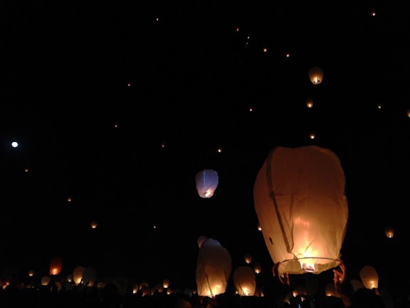 A vibrant lantern festival at dusk, with glowing lanterns floating gently above the monastery grounds.