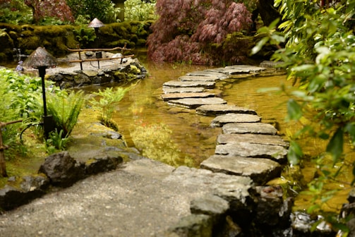 A serene Japanese garden with a stone path and cherry blossoms.