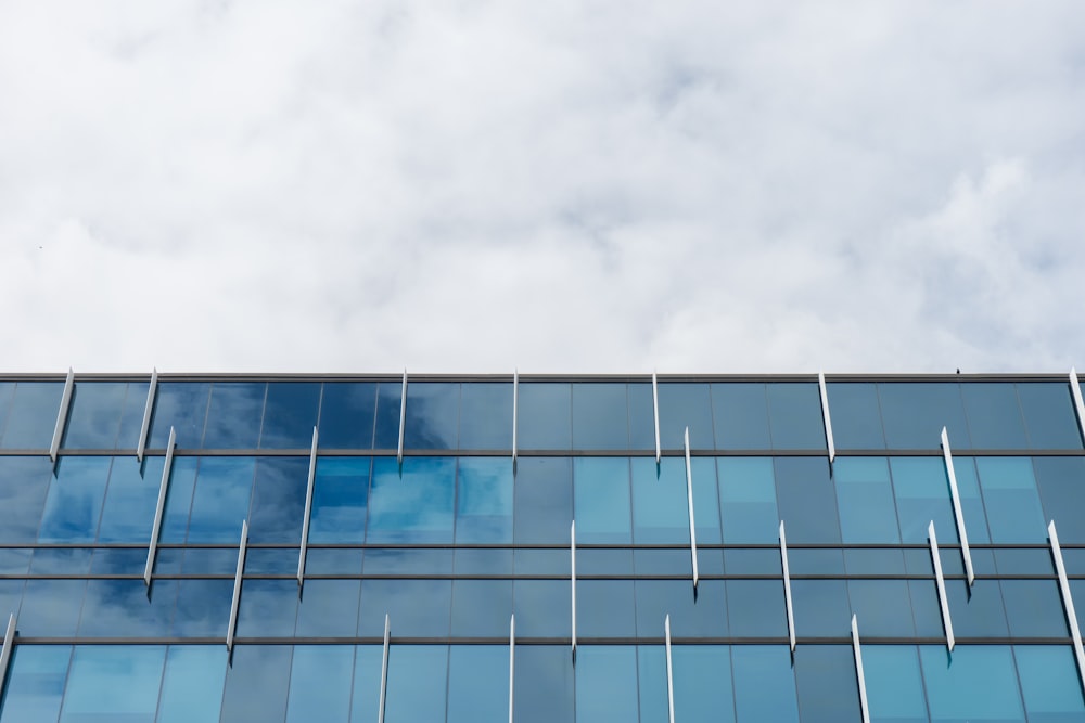 blue glass walled building under white skies