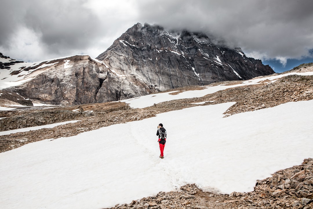 person walking on snow towards mountain