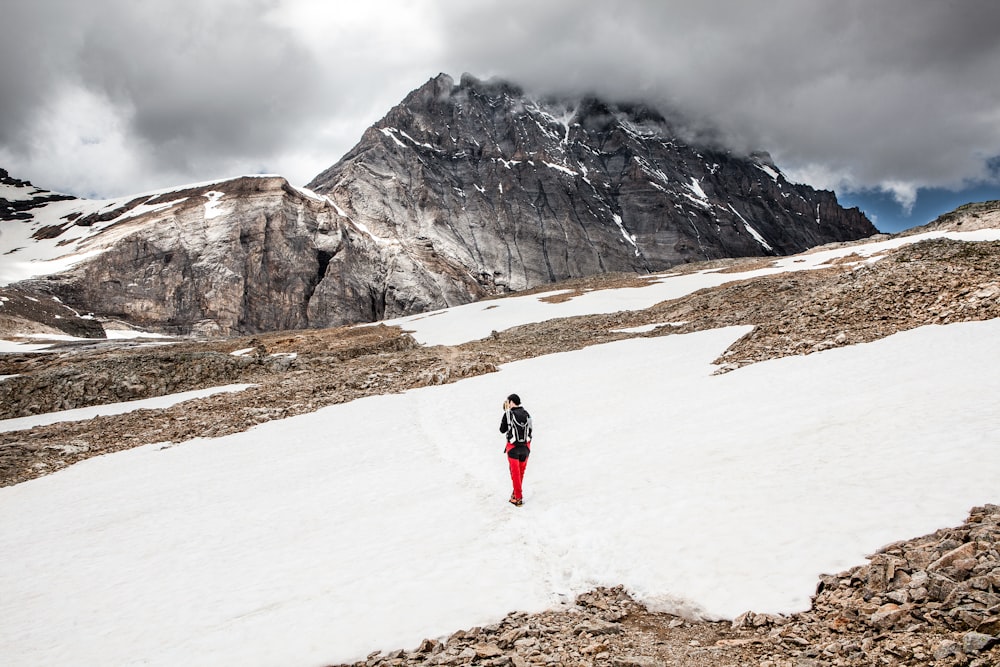 person walking on snow towards mountain