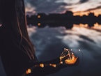 woman holding string lights at dusk
