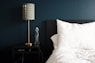 gray table lamp beside white bed pillow