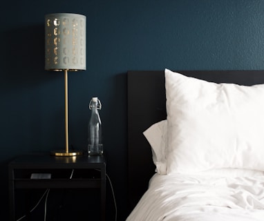 gray table lamp beside white bed pillow