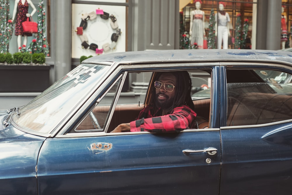 man driving blue car