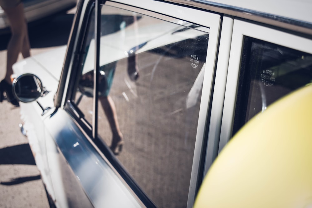 Femme vue marchant dans le reflet d’une fenêtre de voiture