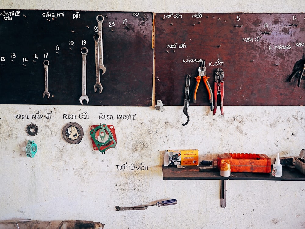 assorted steel tools on brown wall