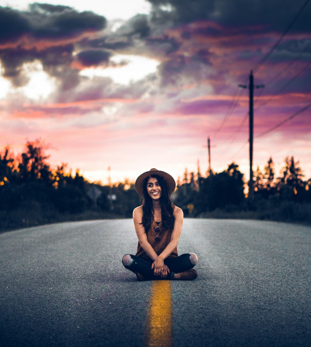 man sitting on concrete road