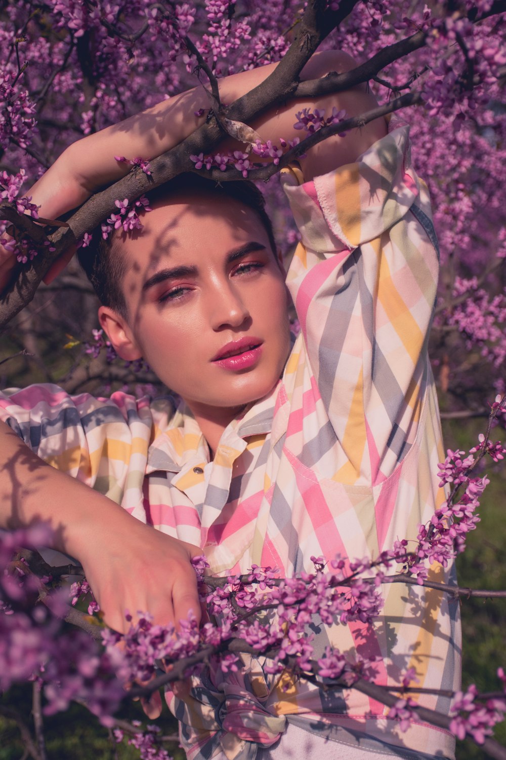 model woman taking photo on purple tree at daytime