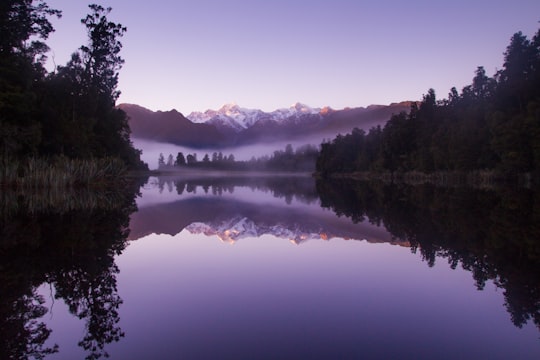 photo of lake near trees in Westland Tai Poutini National Park New Zealand