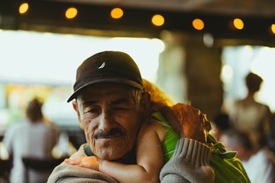 man wearing cap carrying girl inside cafe family reunion google meet background